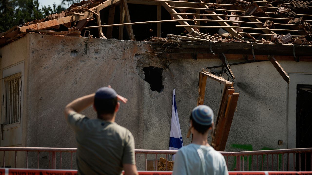 People look at a damaged house that was hit by a rocket fired from Lebanon, near Safed, northern Israel, on Wednesday, Sept. 25, 2024. (AP Photo//Leo Correa)