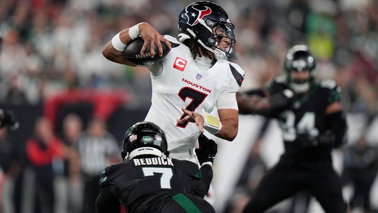 Houston Texans quarterback C.J. Stroud, top, evades a tackle by New York Jets defensive end Haason Reddick during the first half an NFL football game Thursday, Oct. 31, 2024, in East Rutherford, N.J. (AP Photo/Frank Franklin II)