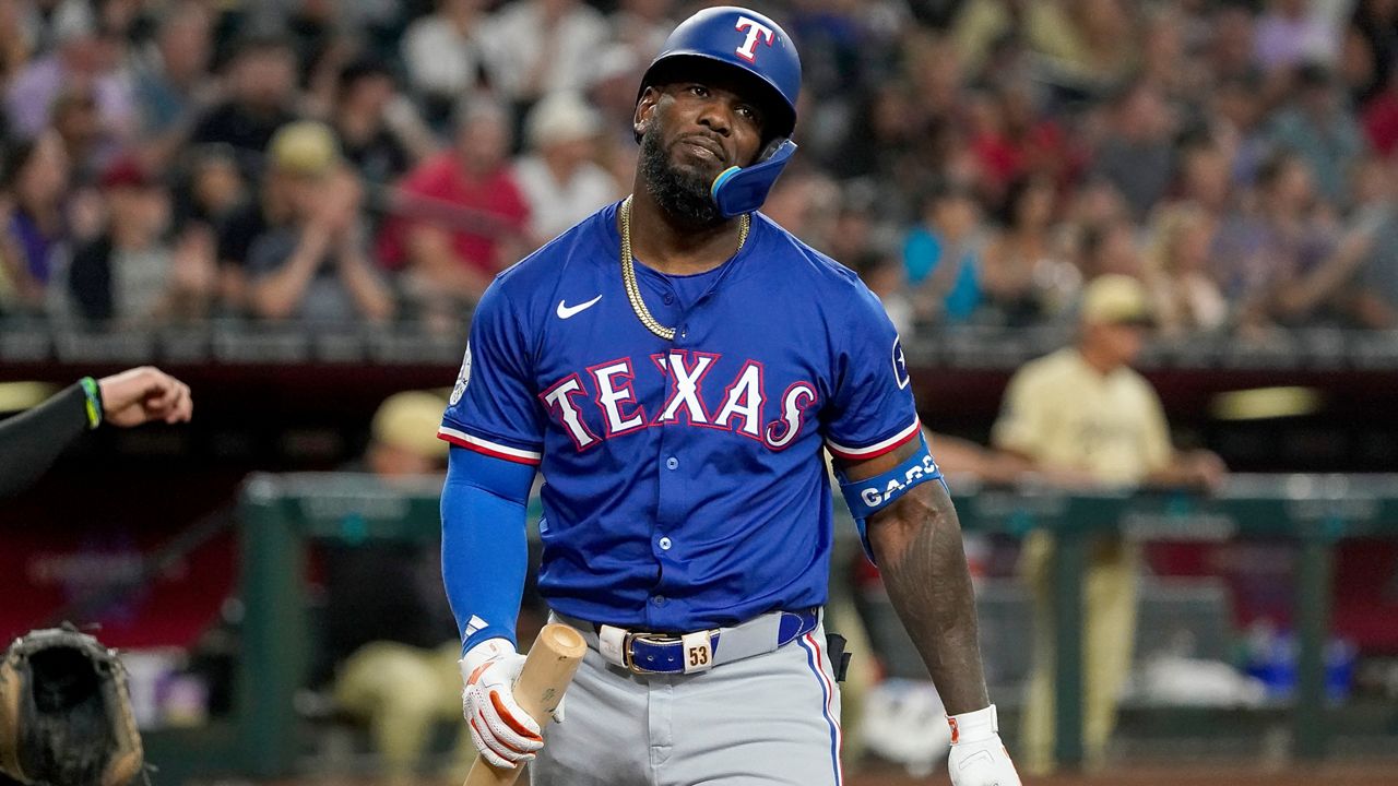 Texas Rangers' Adolis García reacts after striking out against the Arizona Diamondbacks during the fourth inning of a baseball game, Tuesday, Sept. 10, 2024, in Phoenix. (AP Photo/Darryl Webb)