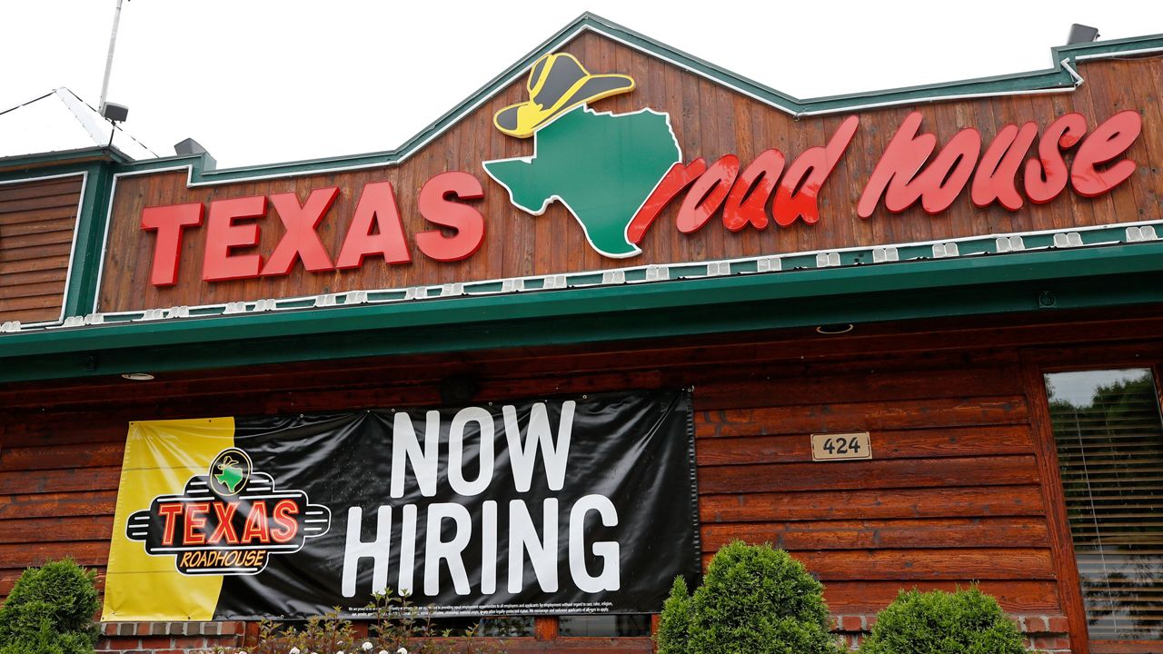 A "Now Hiring" sign is displayed outside a Texas Roadhouse restaurant, Friday, June 5, 2020, in Methuen, Mass. (AP Photo/Elise Amendola)