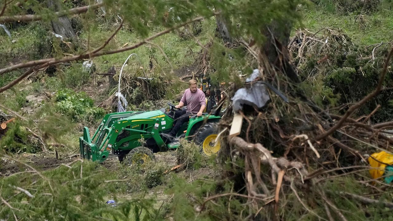 A person drives a tractor as they clean-up along the river after flooding in Kerrville, Texas, Monday, July 7, 2025. (AP Photo/Ashley Landis)