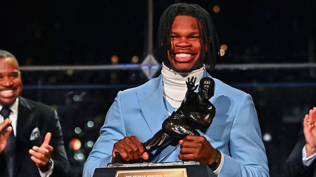 Colorado's Travis Hunter holds the trophy after winning the Heisman Trophy as the outstanding player in college football, Saturday, Dec. 14, 2024, in New York. (Todd Van Emst/Heisman Trust via AP, Pool)