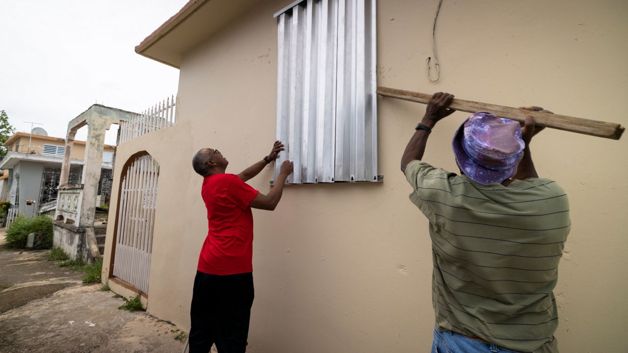 Residents prepare for the arrival of Tropical Storm Fiona, in Loiza, Puerto Rico, Saturday, Sept. 17, 2022. Fiona was expected to become a hurricane as it neared Puerto Rico on Saturday, threatening to dump up to 20 inches (51 centimeters) of rain as people braced for potential landslides, severe flooding and power outages. (AP Photo/Alejandro Granadillo)