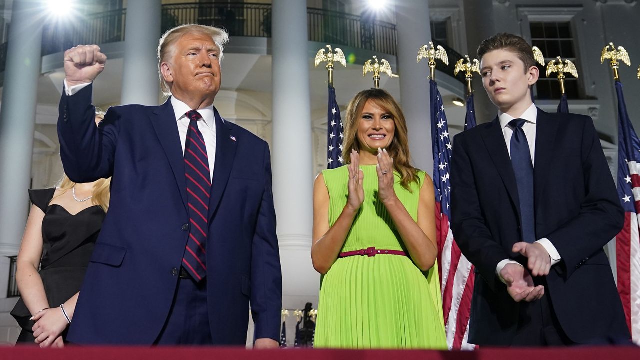 President Donald Trump, first lady Melania Trump and Barron Trump stand on the South Lawn of the White House on the fourth day of the Republican National Convention, Thursday, Aug. 27, 2020, in Washington. (AP Photo/Evan Vucci)