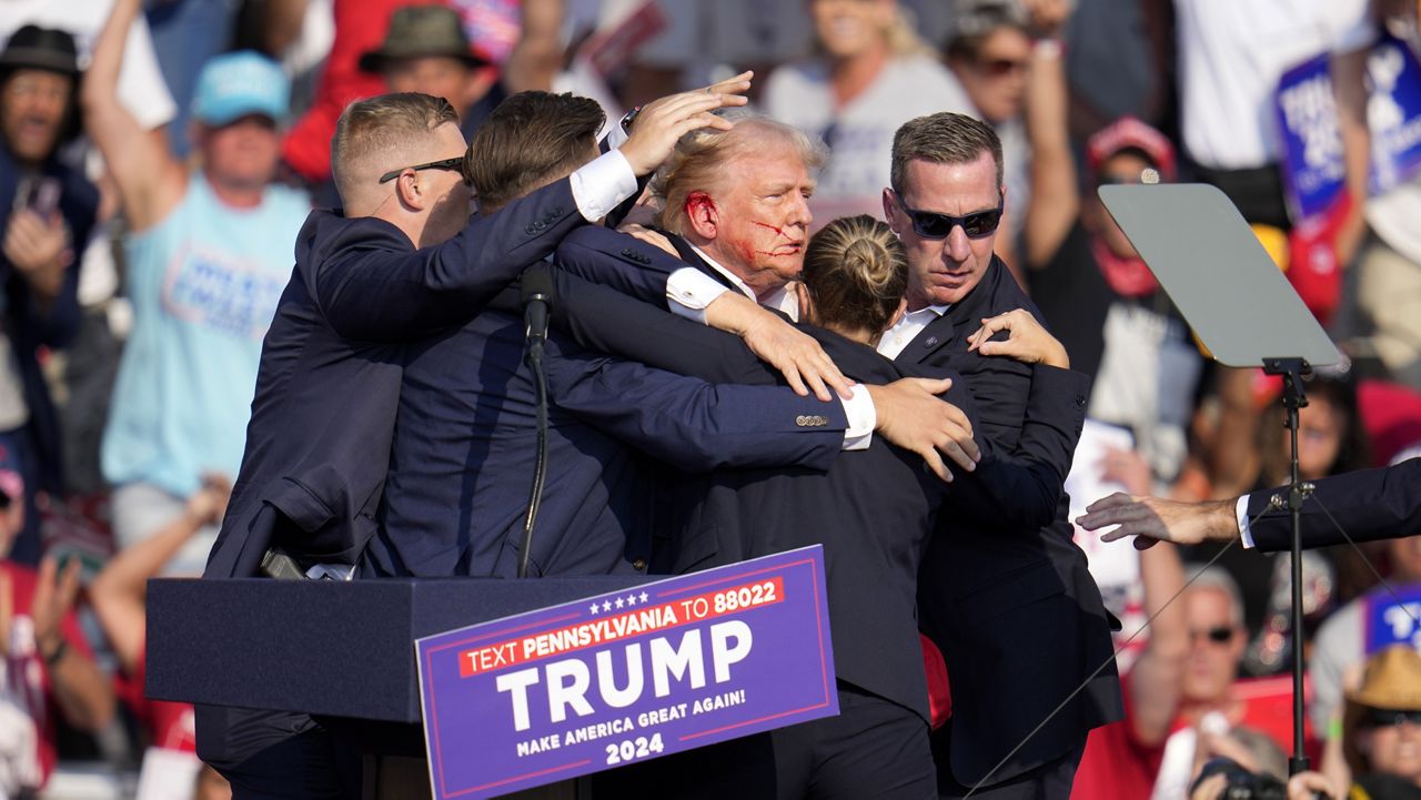 Republican presidential candidate former President Donald Trump is helped off the stage at a campaign event in Butler, Pa., Saturday, July 13, 2024. (AP Photo/Gene J. Puskar)