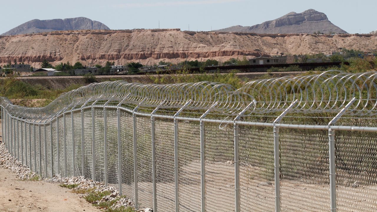 A privately owned fence extends toward the U.S. border, with Mexico in the distance. (AP Photos/Morgan Lee)