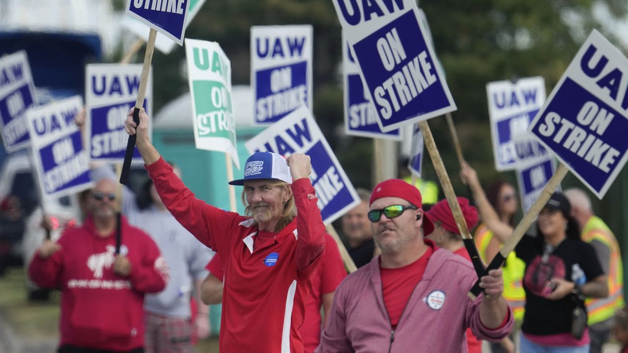 United Auto Workers members walk a picket line during a strike at the Ford Motor Company Michigan Assembly Plant in Wayne, Mich., Friday, Sept. 15, 2023. (AP Photo/Paul Sancya)