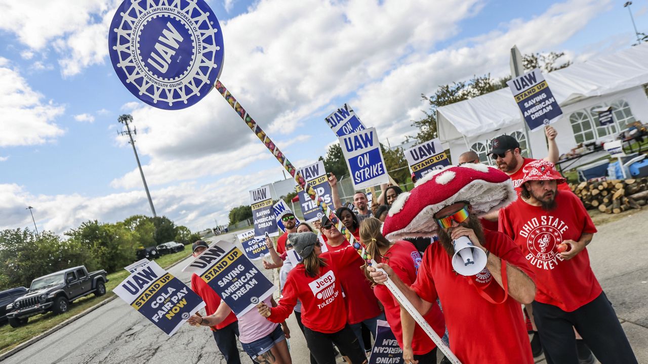 United Auto Workers member Ben Smith, donning a mushroom cap and shades, is joined by other members of engine team 43 while picketing outside the Stellantis Toledo Assembly Complex on Monday, Sept. 18, 2023 in Toledo, Ohio. (Isaac Ritchey/The Blade via AP)