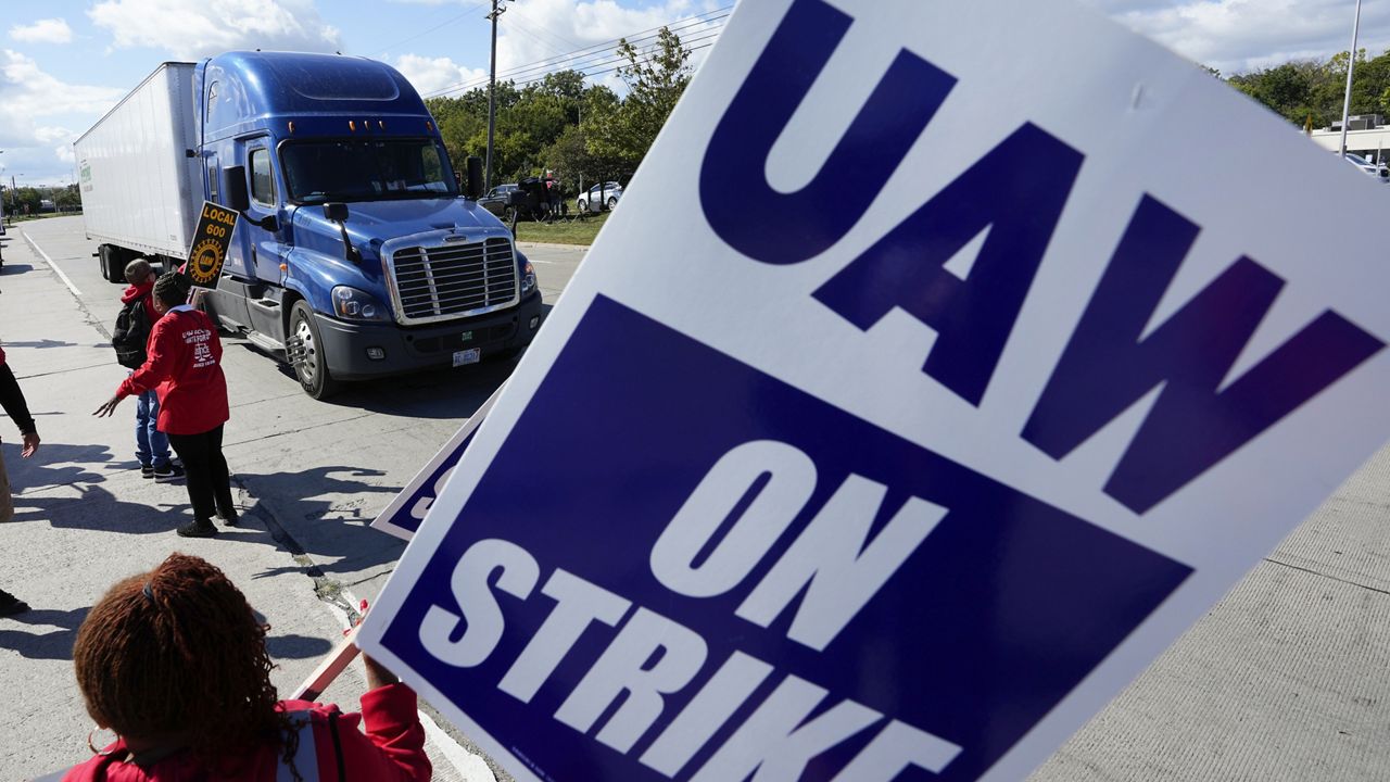 United Auto Workers members walk the picket line blocking a truck from entering the Ford Michigan Assembly Plant in Wayne, Mich., Monday, Sept. 18, 2023. (AP Photo/Paul Sancya)