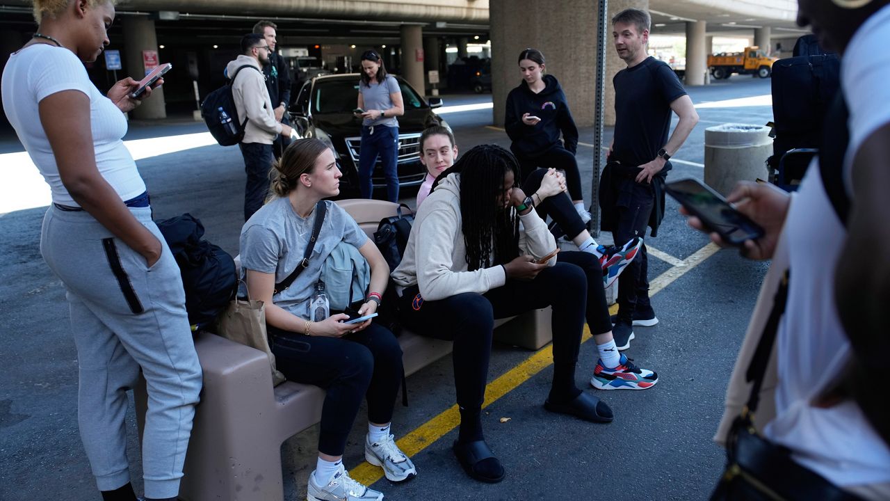 Players and staff of the New York Liberty WNBA basketball team wait to board buses at Harry Reid International Airport, Wednesday, June 28, 2023, in Las Vegas. (AP Photo/John Locher, File)