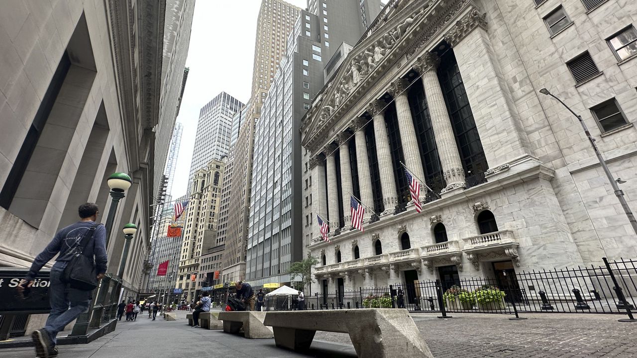 People pass the New York Stock Exchange on July 30, 2024 in New York. (AP Photo/Peter Morgan)