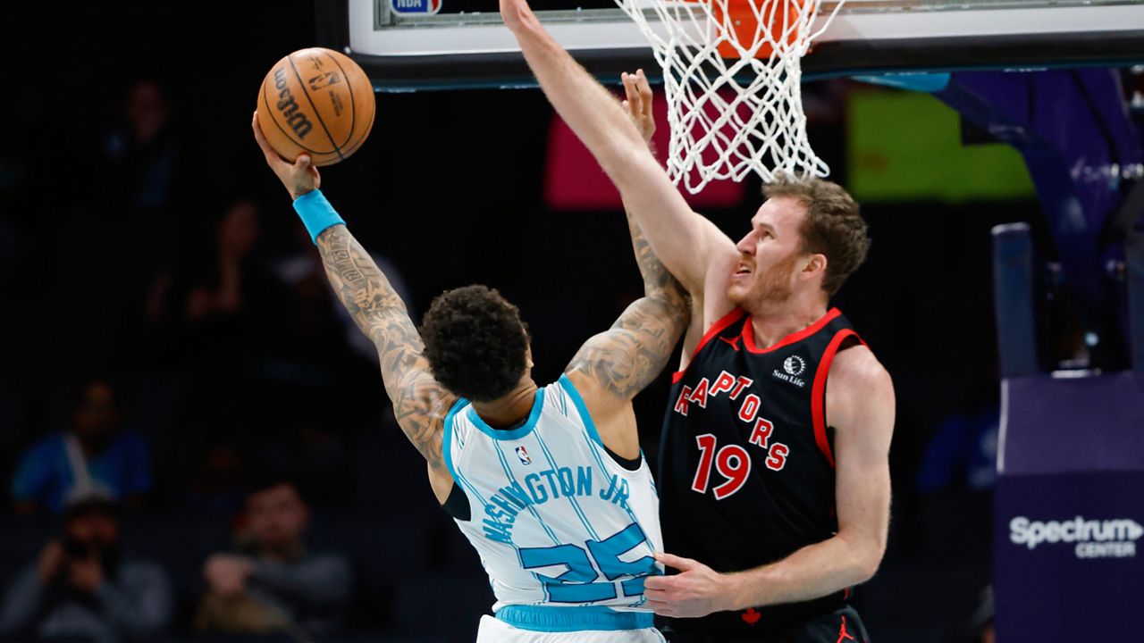 Charlotte Hornets forward P.J. Washington, left, drives to the basket against Toronto Raptors center Jakob Poeltl during the first half of an NBA basketball game in Charlotte, N.C., Wednesday, Feb. 7, 2024. (AP Photo/Nell Redmond)