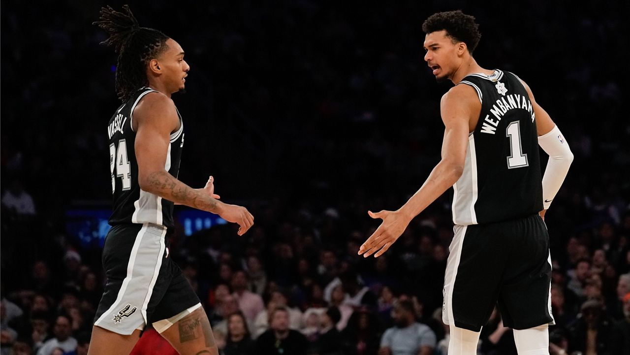 San Antonio Spurs' Victor Wembanyama, right, and Devin Vassell react during the first half of an NBA basketball game against the New York Knicks, Wednesday, Dec. 25, 2024, in New York. (AP Photo/Seth Wenig)