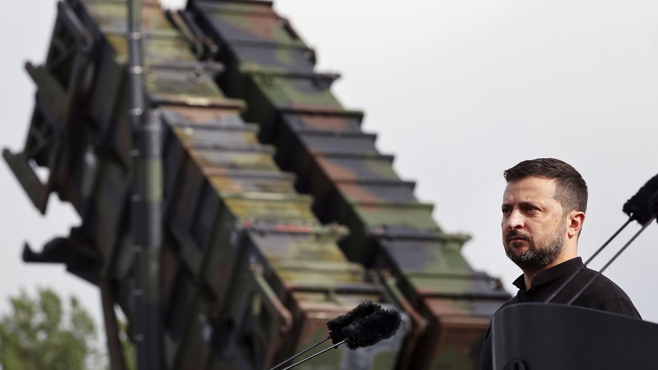 Ukraine's President Volodymyr Zelenskyy stands in front of a Patriot air defense missile system during a visit to a military training area in the German state of Western Pomerania, Tuesday, June 11, 2024, to learn about the training of Ukrainian soldiers on the "Patriot" air defence missile system. (Jens Buettner/dpa via AP)