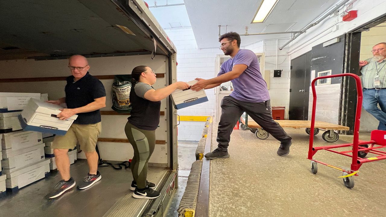 people load boxes of signatures into a truck