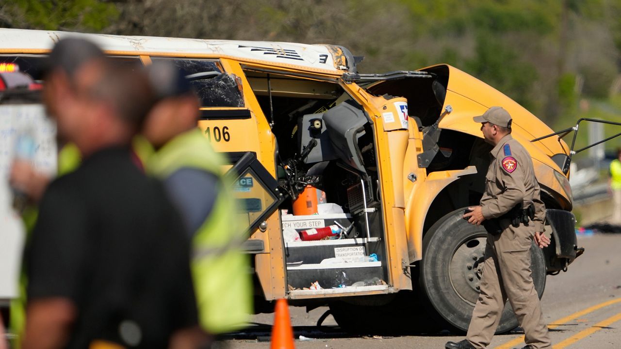 A Texas Department of Public Safety trooper inspects the scene of a fatal school bus crash on Texas State Highway 21 near Caldwell Road on Friday, March 22, 2024, in Bastrop, Texas. (Jay Janner/Austin American-Statesman via AP)
