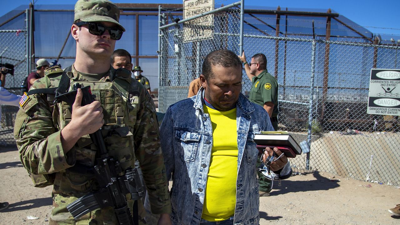 Migrants are escorted by a U.S. Army soldier after entering into El Paso, Texas from Ciudad Juarez, Mexico to be processed by immigration authorities, May 10, 2023. (AP Photo/Andres Leighton)