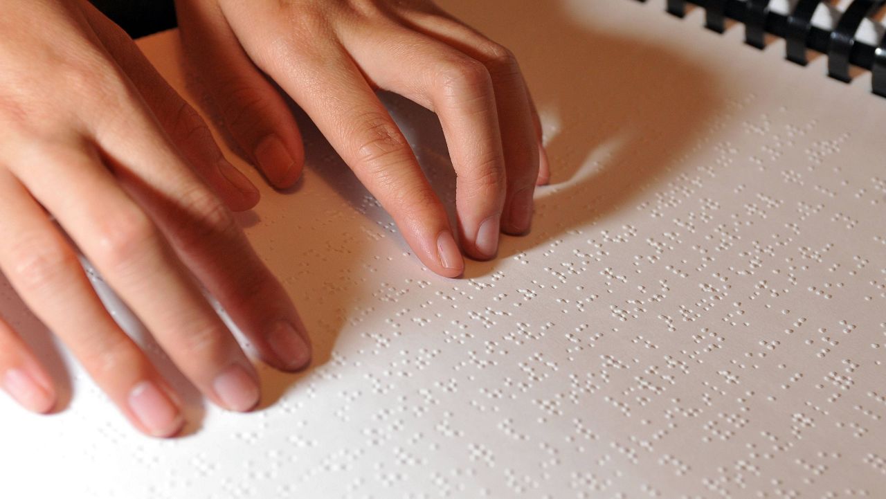 Winona Brackett, 12, read from her Braille science school book on Wednesday, March 25, 2009, in Stuart, Fla. (AP Photo/Steve Mitchell)