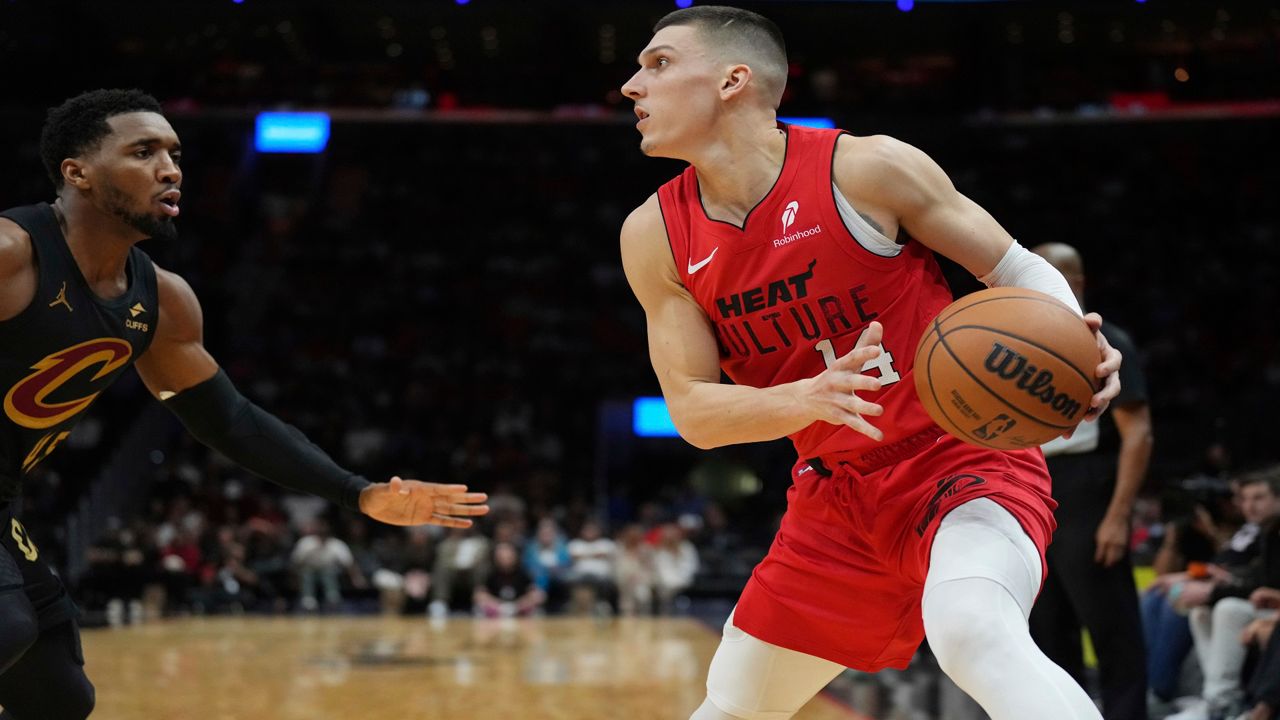 Miami Heat guard Tyler Herro sets to take a shot as Cleveland Cavaliers guard Donovan Mitchell, left, defends during the first half of an NBA basketball game, Sunday, Dec. 8, 2024, in Miami. (AP Photo/Jim Rassol)