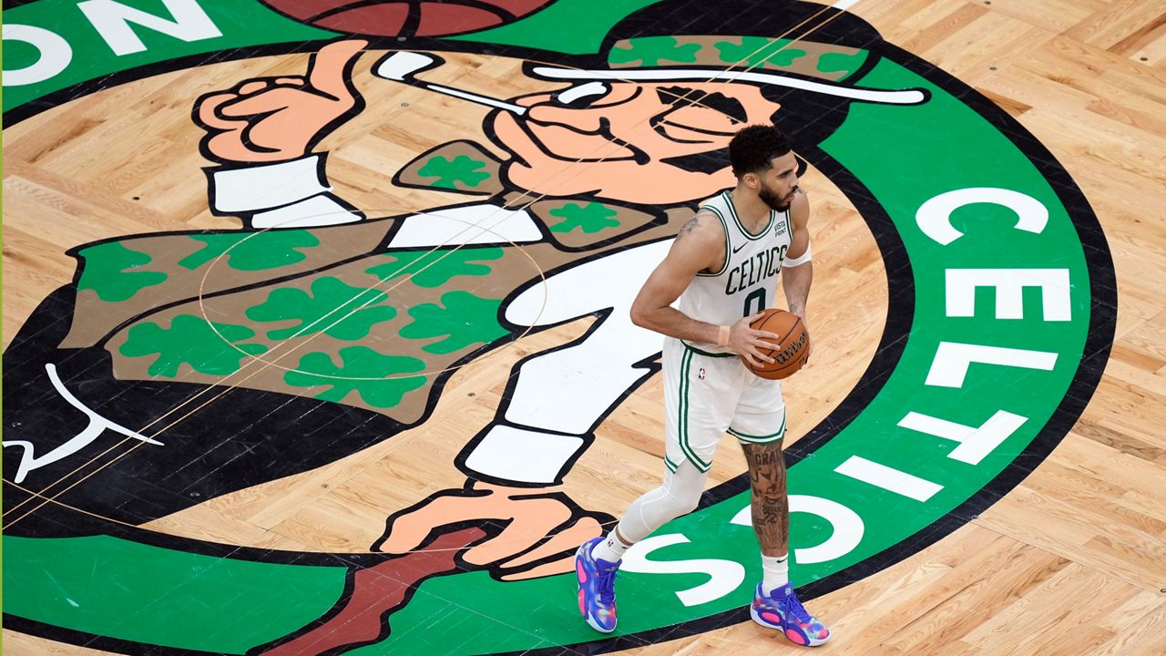 Boston Celtics' Jayson Tatum (0) holds the ball near midcourt during the second half of Game 1 of the basketball team's NBA Finals against the Dallas Mavericks on Thursday, June 6, 2024, in Boston.(AP Photo/Michael Dwyer)
