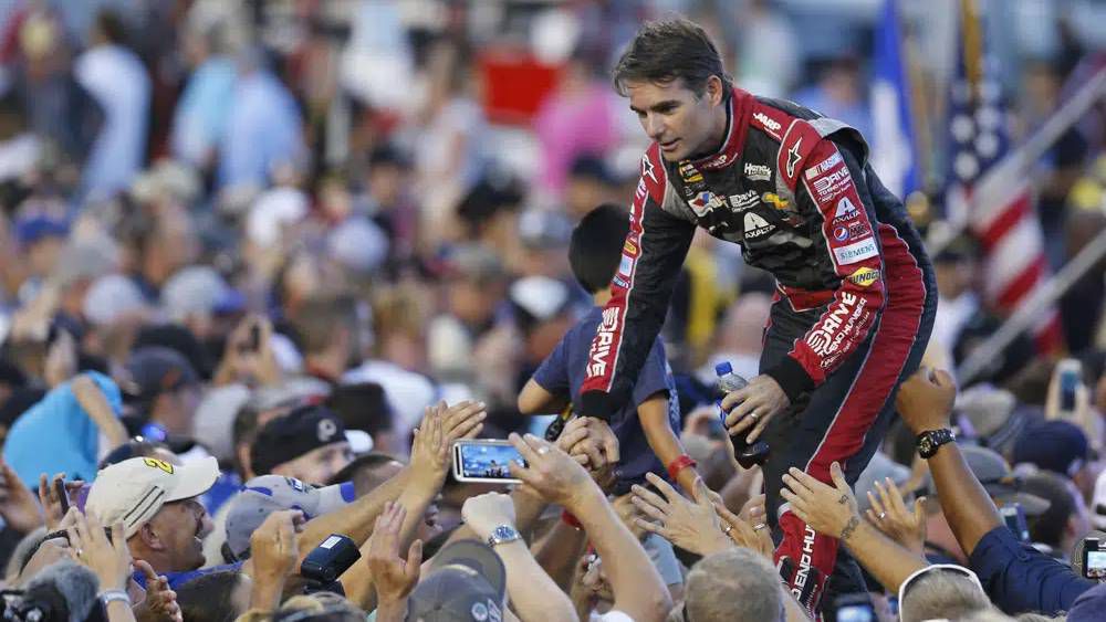 Jeff Gordon greets fans during driver introductions prior to the start of the NASCAR Sprint Cup race at Richmond International Raceway in Richmond, Va., Saturday, Sept. 6, 2014. Denny Hamlin, one of NASCAR's current veterans and also the co-owner alongside Michael Jordan of 23XI Racing, has long noticed the waning mainstream popularity of the Cup stars since the retirements of Jeff Gordon, Tony Stewart, Carl Edwards, Danica Patrick, Matt Kenseth and Johnson. (AP Photo/Steve Helber)