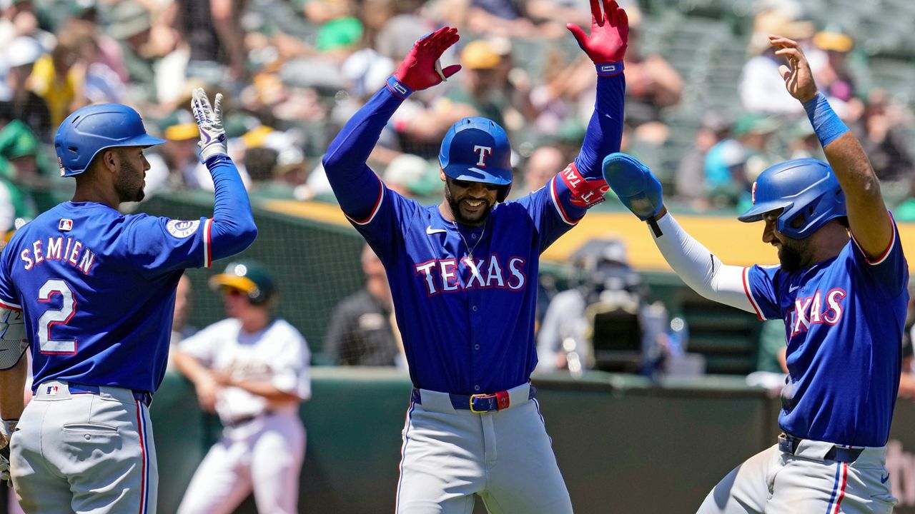 Texas Rangers' Leody Taveras, center, celebrates with Marcus Semien, left, and Ezequiel Duran after hitting a two-run home run against the Oakland Athletics during the fourth inning in the first baseball game of a doubleheader Wednesday, May 8, 2024, in Oakland, Calif. (AP Photo/Godofredo A. Vásquez)