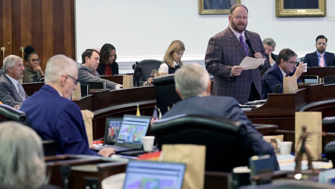 While other senators look at the map on their computers, Sen. Ralph Hise (R-Mitchell), top right, one of the sponsors of a congressional redistricting bill, speaks as the North Carolina Senate debates the bill at the Legislative Building, Tuesday, Oct. 24, 2023, in Raleigh, N.C. (AP Photo/Chris Seward)