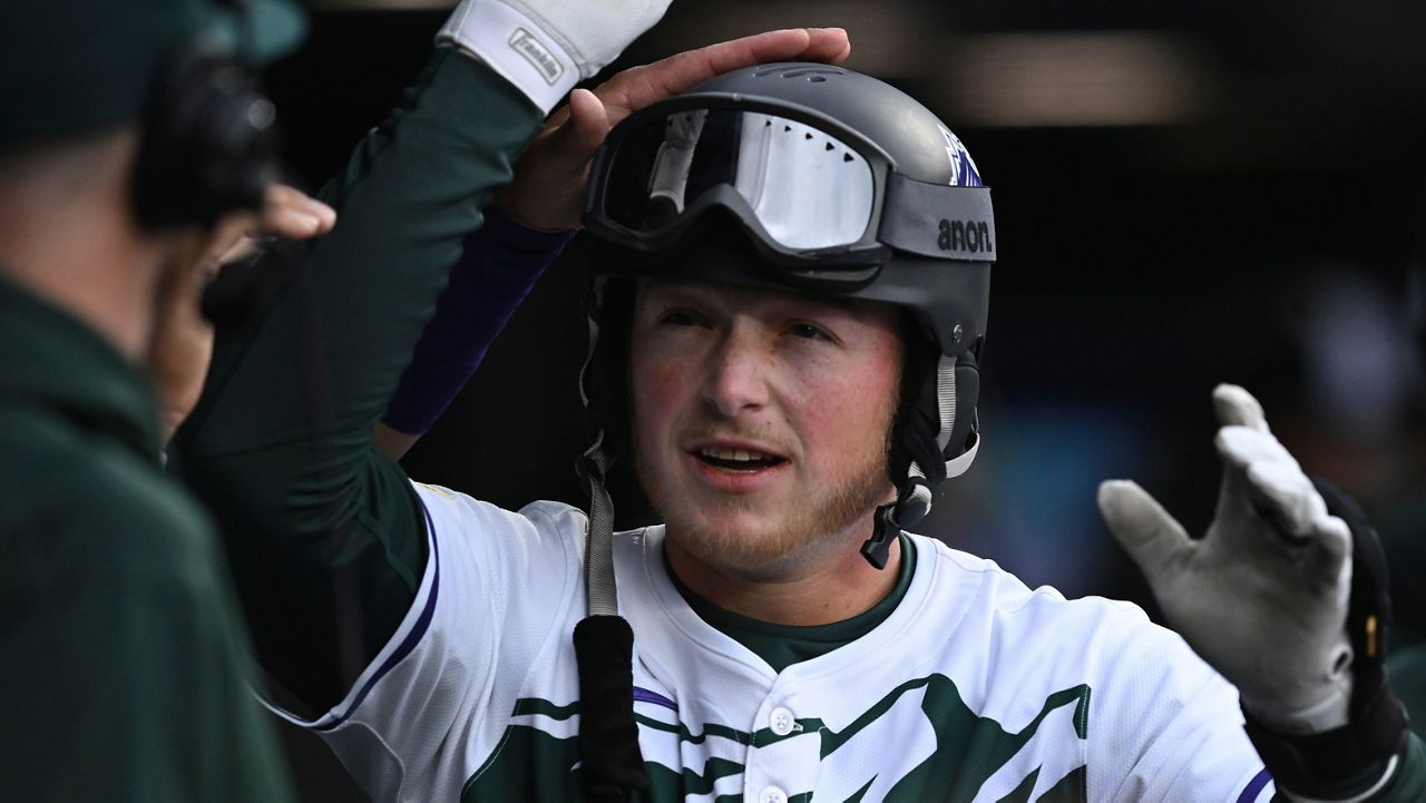 Colorado Rockies' Hunter Goodman is congratulated in the dugout after hitting a home run in the third inning of a baseball game against the Texas Rangers, Saturday, May 11, 2024, in Denver. (AP Photo/Jerilee Bennett)