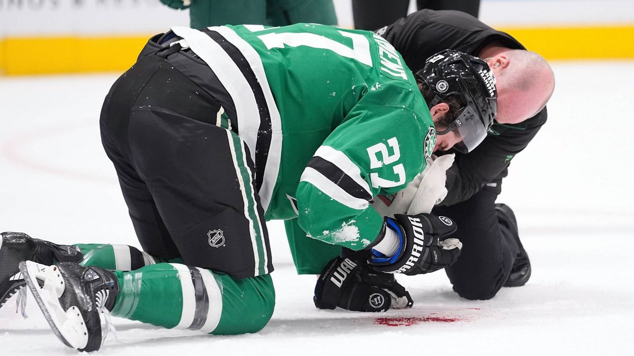 Dallas Stars left wing Mason Marchment (27) is tended to after he was hit by the puck during the first period of an NHL hockey game against the Minnesota Wild, Friday, Dec. 27, 2024, in Dallas. (AP Photo/LM Otero)