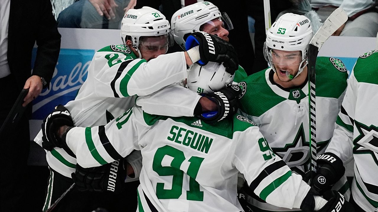 Dallas Stars center Tyler Seguin, front, is congratulated after scoring an empty-net goal against the Colorado Avalanche during the third period of Game 3 of an NHL hockey Stanley Cup playoff series Saturday, May 11, 2024, in Denver. (AP Photo/David Zalubowski)