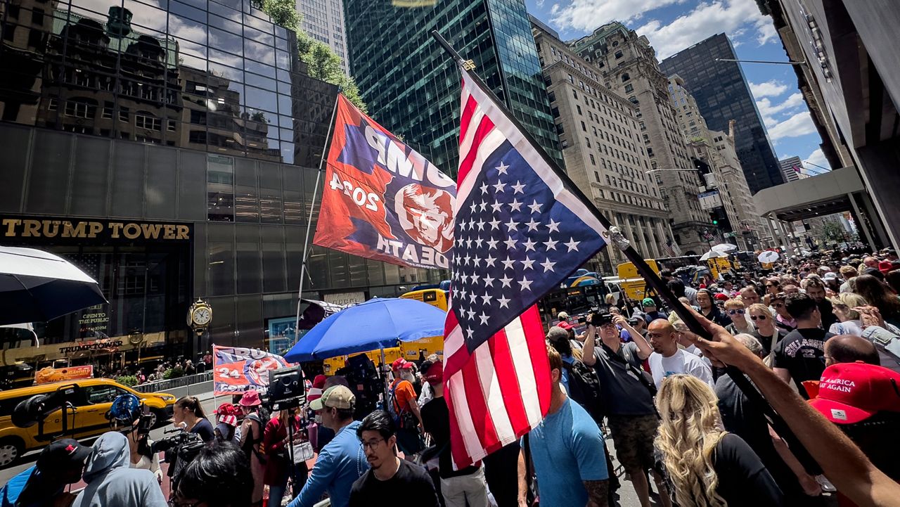 A supporter of former President Donald Trump waves an inverted American flag during a demonstration outside Trump Tower, Friday, May 31, 2024, in New York. A day after a New York jury found Trump guilty of 34 felony charges, the presumptive Republican presidential nominee addressed the conviction and likely attempt to cast his campaign in a new light. (AP Photo/John Minchillo)