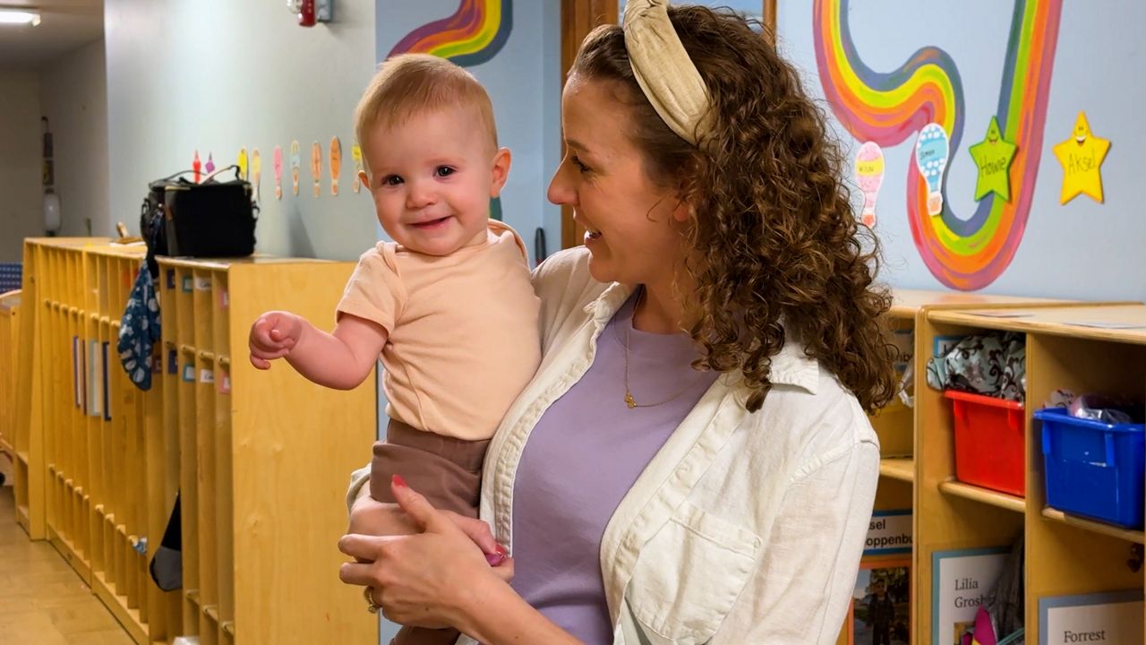Alaina Campbell holds her 7-month-old daughter, Lucie, at Arthouse Preschool in Waunakee, Wis. (Spectrum News 1/Mandy Hague)
