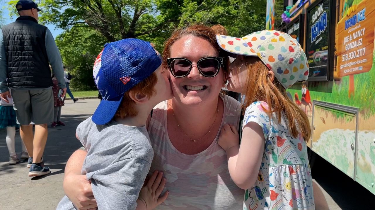 Allison Armstrong, a mother of three, gets a kiss on the cheek from two of her three kids.
