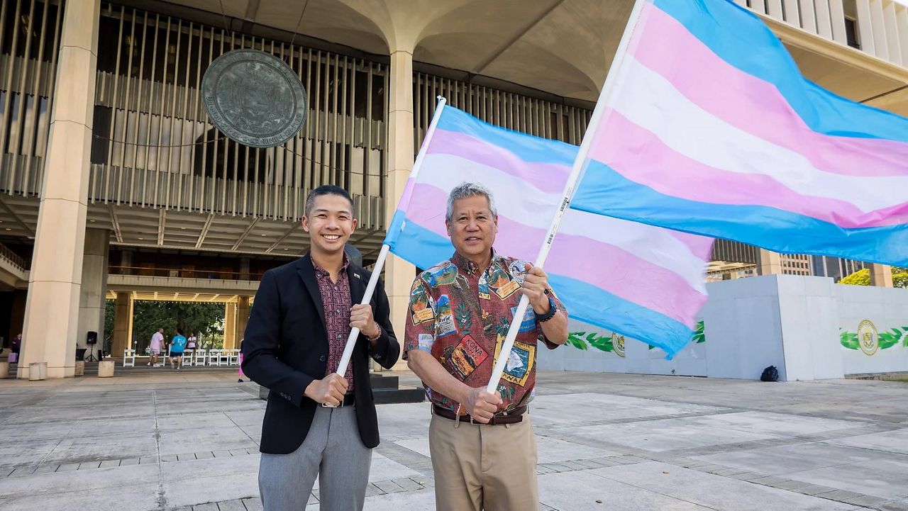 State Rep. Adrian Tam and House Speaker Scott Saiki flew transgender flags in front of the State Capitol in celebration of the upcoming International Transgender Visibility Day. (State House Majority)
