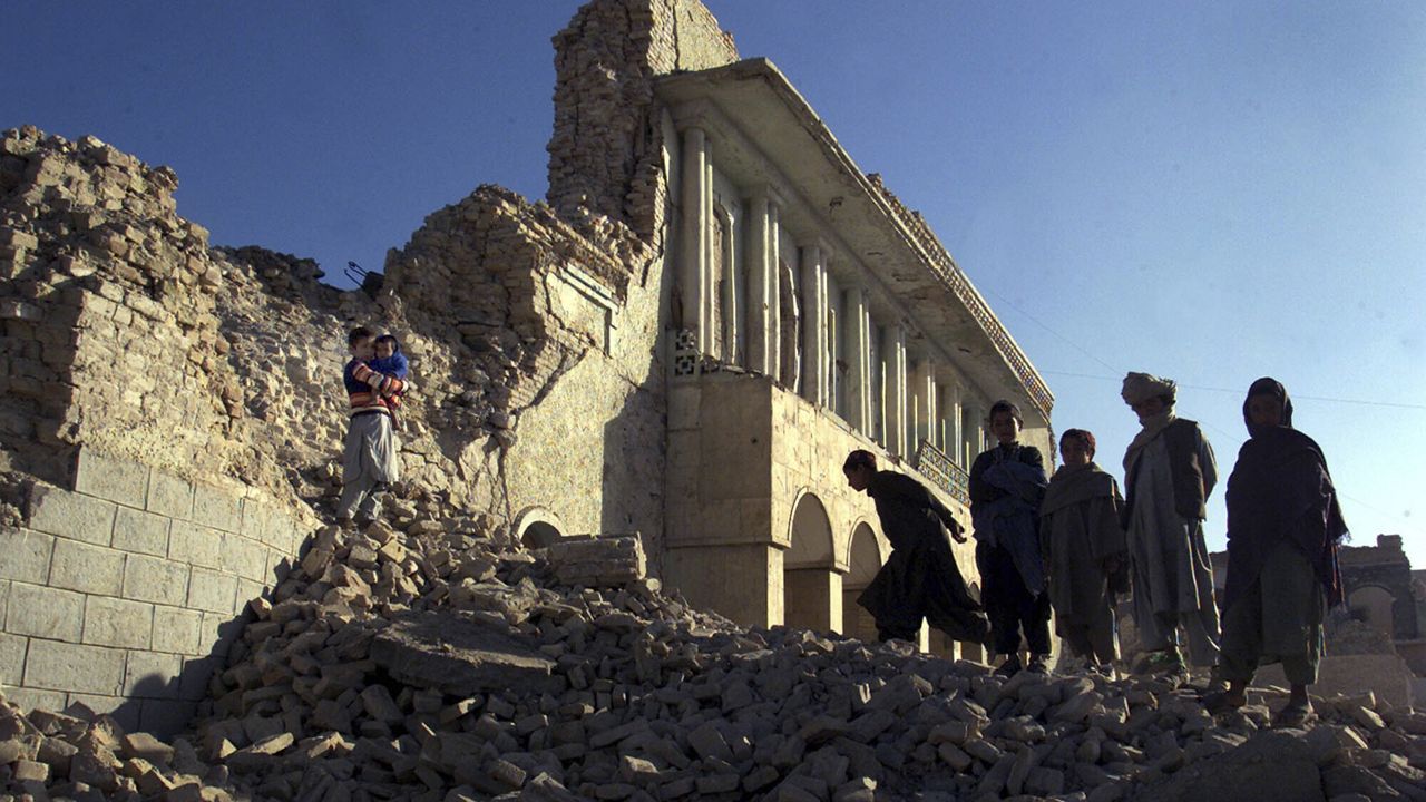 Children walk through the rubble of the former Ministry of the Prevention of Vice and Promotion of Virtue in Kandahar, Afghanistan, Saturday, Dec. 29, 2001. (AP Photo/John Moore)