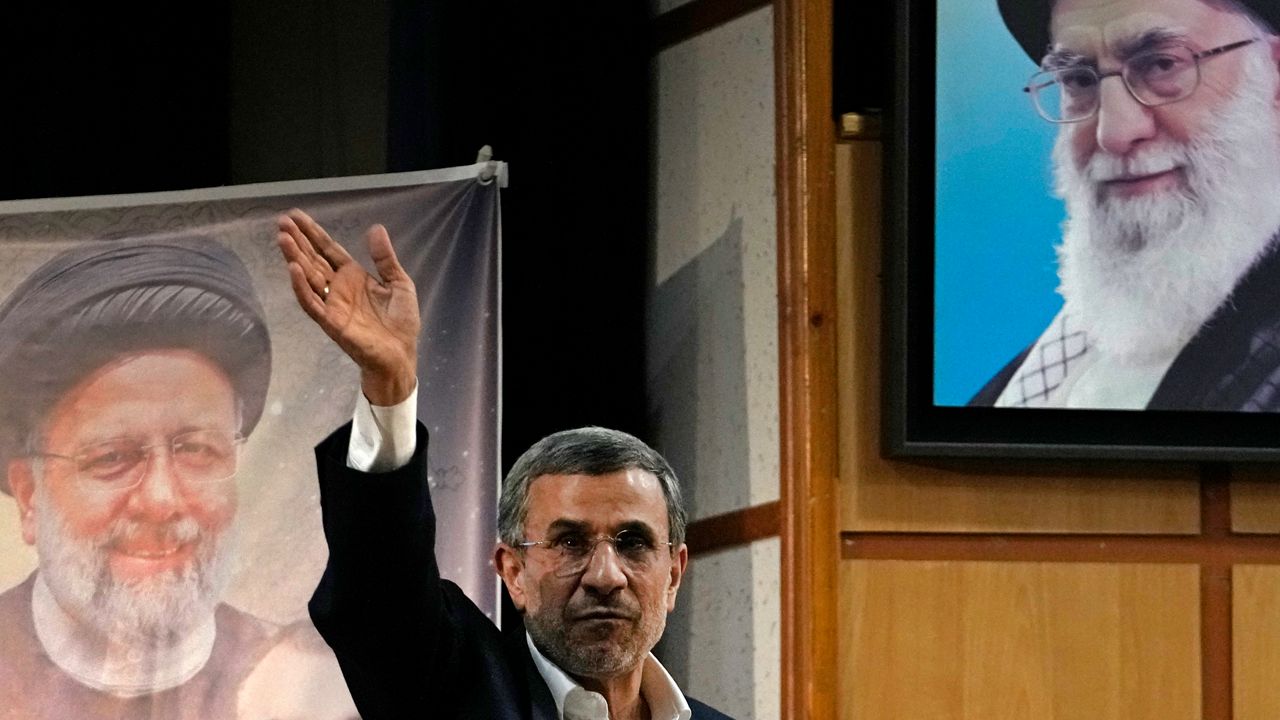 Iran's hard-line former President Mahmoud Ahmadinejad waves to the media as he leaves at the conclusion of a press briefing beside portraits of the Supreme Leader Ayatollah Ali Khamenei, top right, and the late President Ebrahim Raisi after registering his name as a candidate for the June 28 presidential election at the Interior Ministry, in Tehran, Iran, Sunday, June 2, 2024. Ahmadinejad registered Sunday as a possible candidate for the presidential election, seeking to regain the country's top political position after a helicopter crash killed the nation's president. (AP Photo/Vahid Salemi)