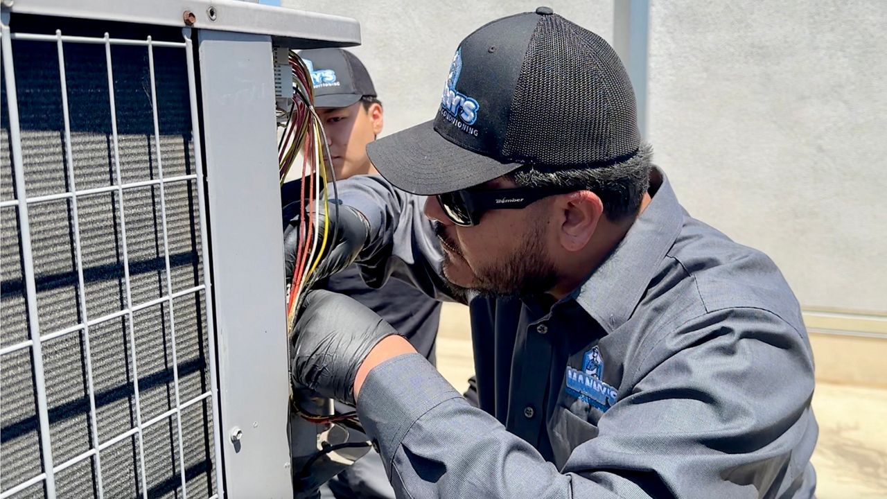 Manny Saavedra repairs an air conditioner in Koreatown. (Spectrum News/Logan Hall)