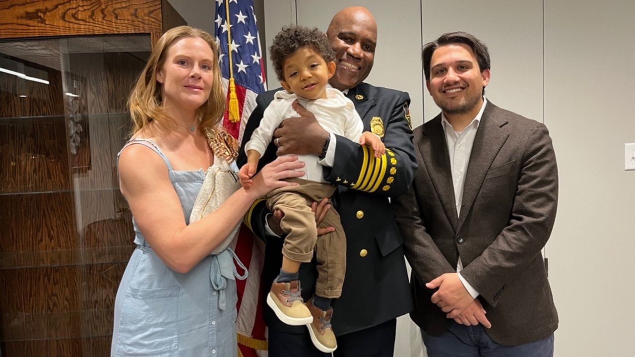 Akron's new fire chief, Leon Henderson, poses for a photo at the swearing in ceremony with his family and Akron's mayor. From left to right: Chief Henderson’s wife Sarah Henderson, their son Abraham Henderson, Leon Henderson and Mayor Shammas Malik. 