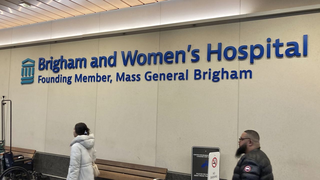 People walk past a sign at Brigham and Women's Hospital in Boston, Wednesday, Jan. 3, 2024. Flooding from a burst water main at the hospital on Sunday, Dec. 24, 2023, has disrupted services for about 200 patients seeking to have children through in vitro fertilization, leaving some of them devastated. (AP Photo/Steve LeBlanc)