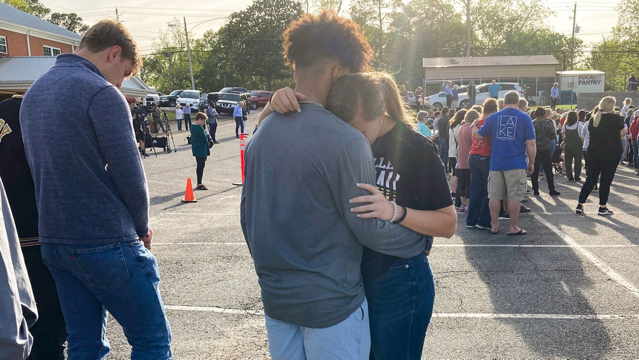 Two teens embrace at a prayer vigil on Sunday, April 16, 2023, outside First Baptist Church in Dadeville, Ala. Several people were killed and over two dozen were injured in a shooting at a teen birthday party in the town on Saturday, April 15. (AP Photo/Jeff Amy)