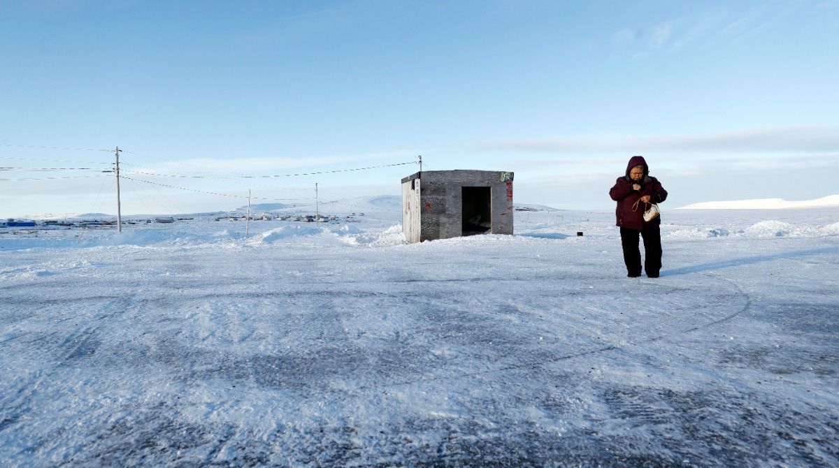 Woman walking on frozen ground in rural Alaska
