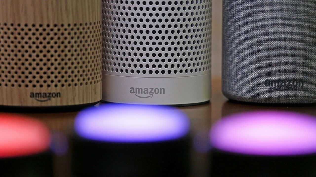 Amazon Echo and Echo Plus devices, behind, sit near illuminated Echo Button devices during an event by the company in Seattle, Sept. 27, 2017. (AP Photo/Elaine Thompson)