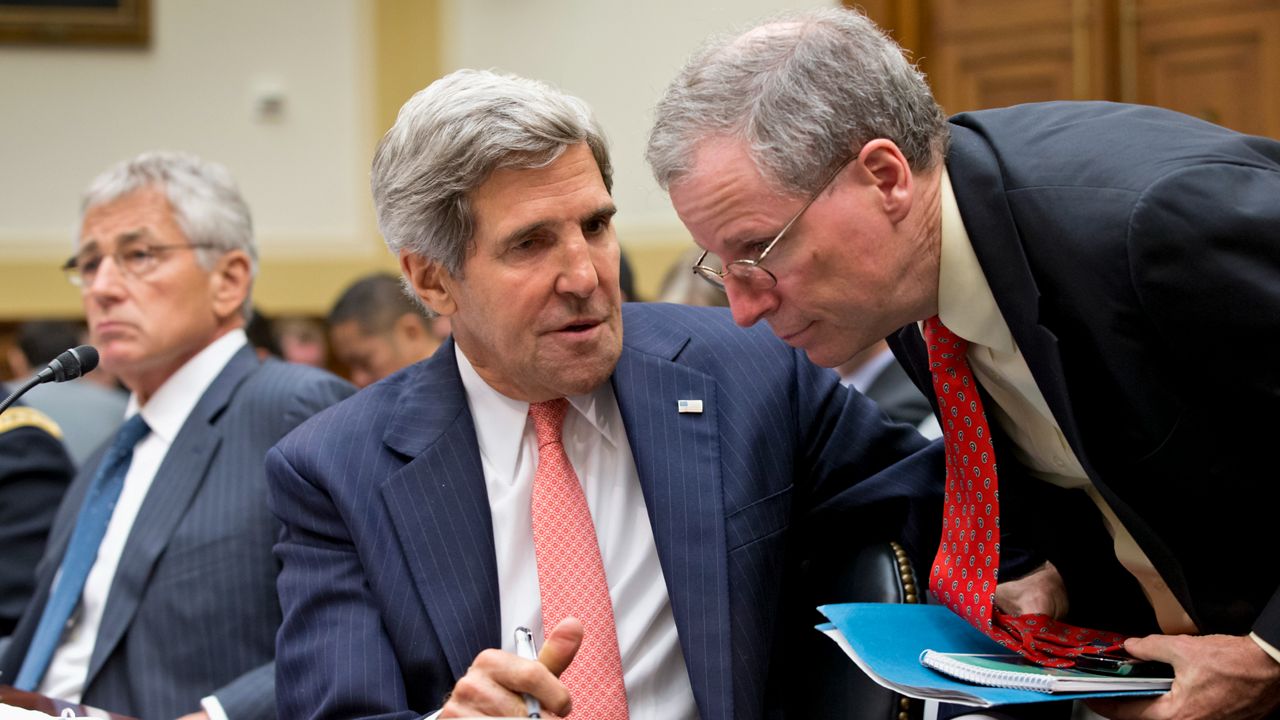 Then-U.S. Ambassador to Syria Robert Ford, right, confers with then-Secretary of State John Kerry, left, on Capitol Hill in Washington, Wednesday, Sept. 4, 2013, during a House Foreign Affairs Committee hearing. (AP Photo/J. Scott Applewhite)