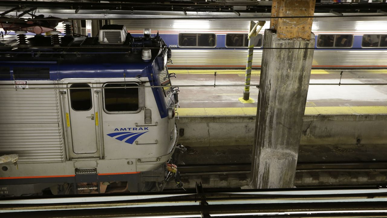 An orange-painted beam, where work has begun on the new Moynihan transit hub, is visible beside an Amtrak train waiting at a platform beneath Penn Station, Monday, May 13, 2013, in New York. (AP Photo/Kathy Willens)