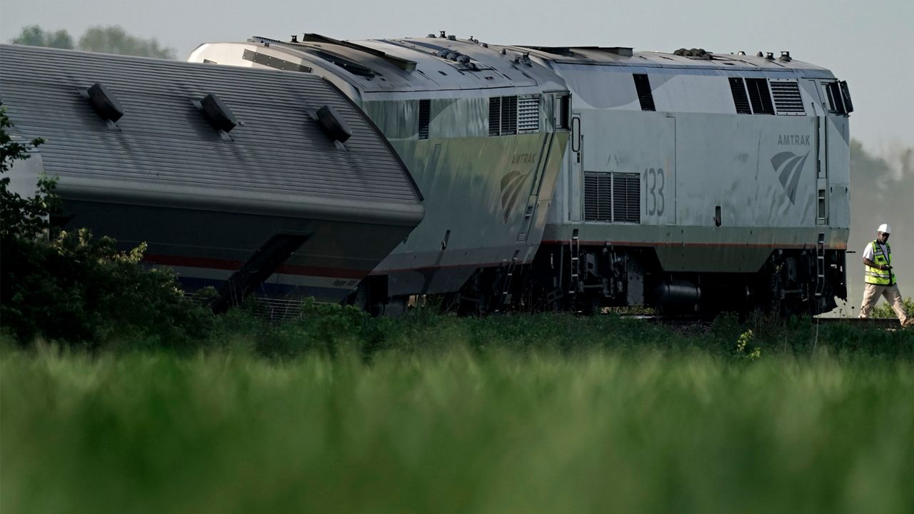 A worker inspects the scene of an Amtrak train that derailed after striking a dump truck, June 27, 2022, near Mendon, Mo. The poor design of a rural Missouri railroad crossing contributed to the fatal Amtrak derailment in 2022 that killed four people and injured 146 others, the National Transportation Safety Board said Wednesday, Aug. 2, 2023. (AP Photo/Charlie Riedel)