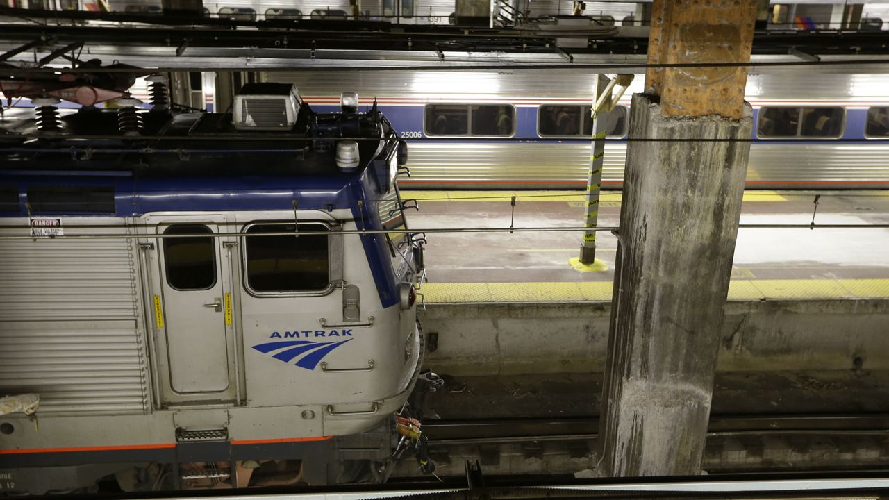 Travelers wait to board their trains at Penn Station in New York on Sunday, Dec. 31, 2023.