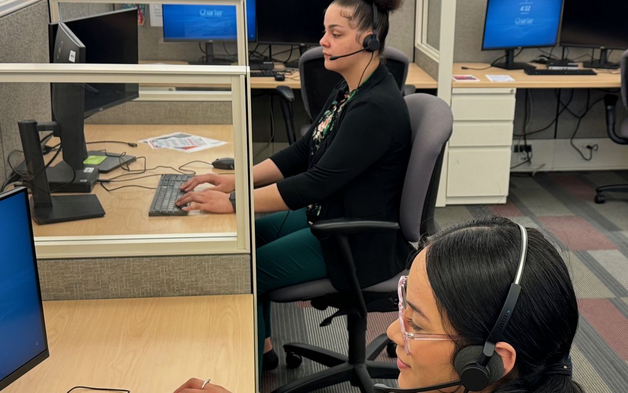 Spectrum interns Kamryn Hufstedler and Anabel Rico help customers with their internet and phone service questions. They are part of a new internship program for high school seniors that offer pay and benefits. (Photo by Wes Shirley)