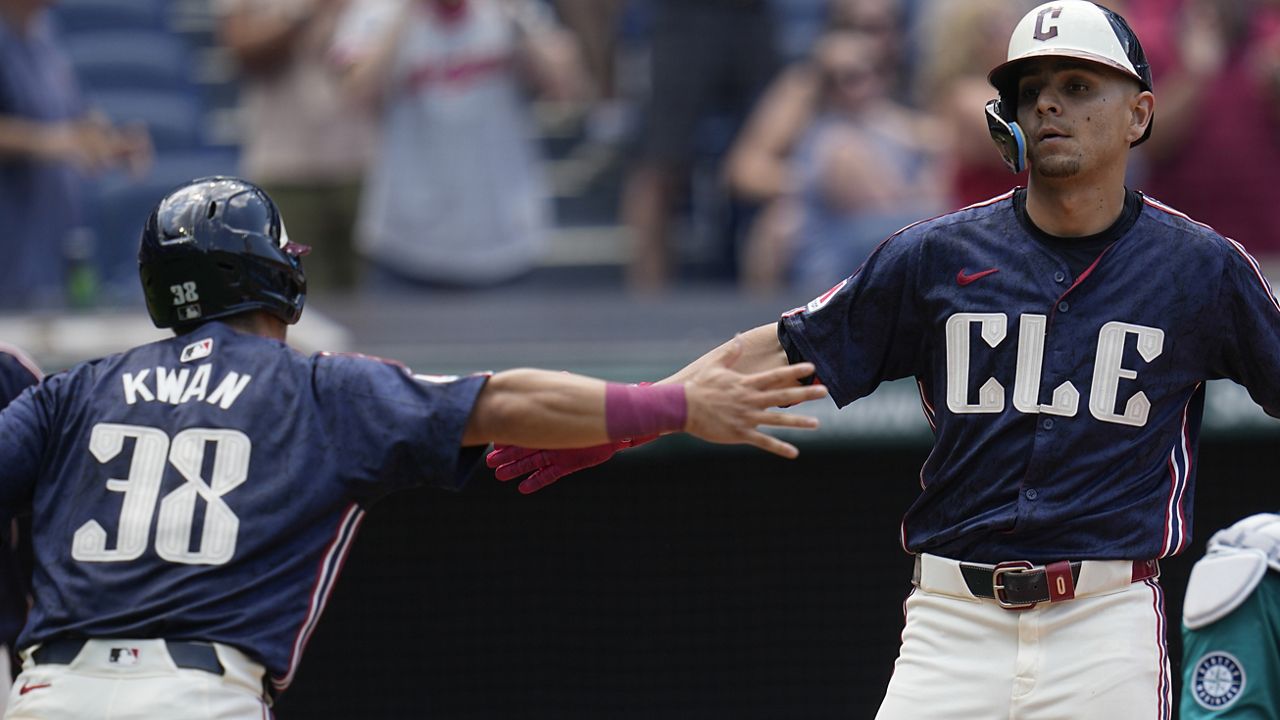 Cleveland Guardians' Andres Gimenez, right, is congratulated by teammate Steven Kwan (38) as he crosses home plate with a home run in the fifth inning of a baseball game against the Seattle Mariners, Thursday, June 20, 2024, in Cleveland. (AP Photo/Sue Ogrocki)