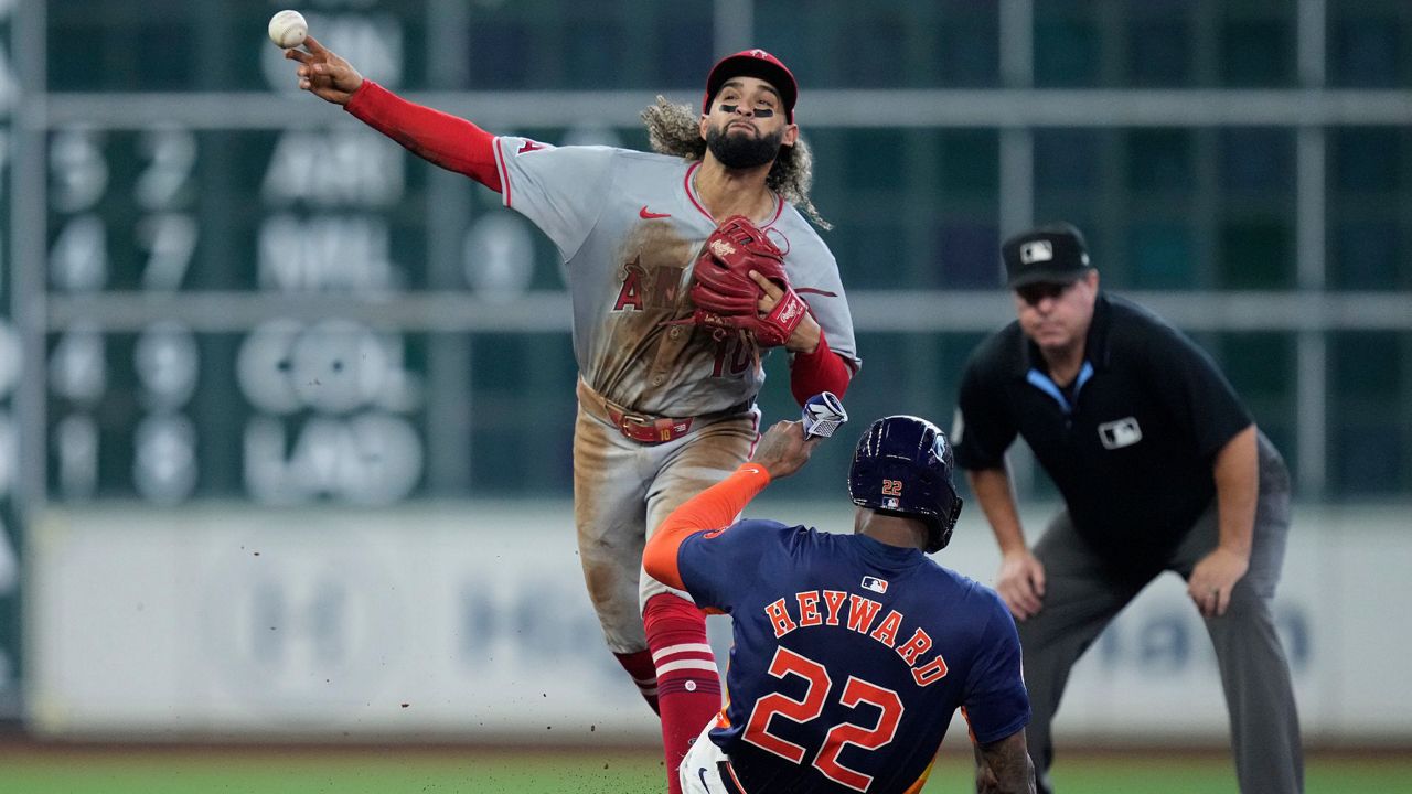 Los Angeles Angels second baseman Jack López (10) turns a double play on Houston Astros' Jake Meyers after forcing out Jason Heyward (22) during the sixth inning of a baseball game Sunday, Sept. 22, 2024, in Houston. (AP Photo/Kevin M. Cox)