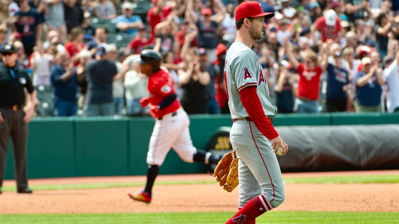 Los Angeles Angels starting pitcher Griffin Canning, foreground, walks from the mound after giving up a two-run home run to Cleveland Guardians' Jose Ramirez, rear, during the sixth inning of a baseball game in Cleveland, Sunday, May 5, 2024. (AP Photo/Phil Long)